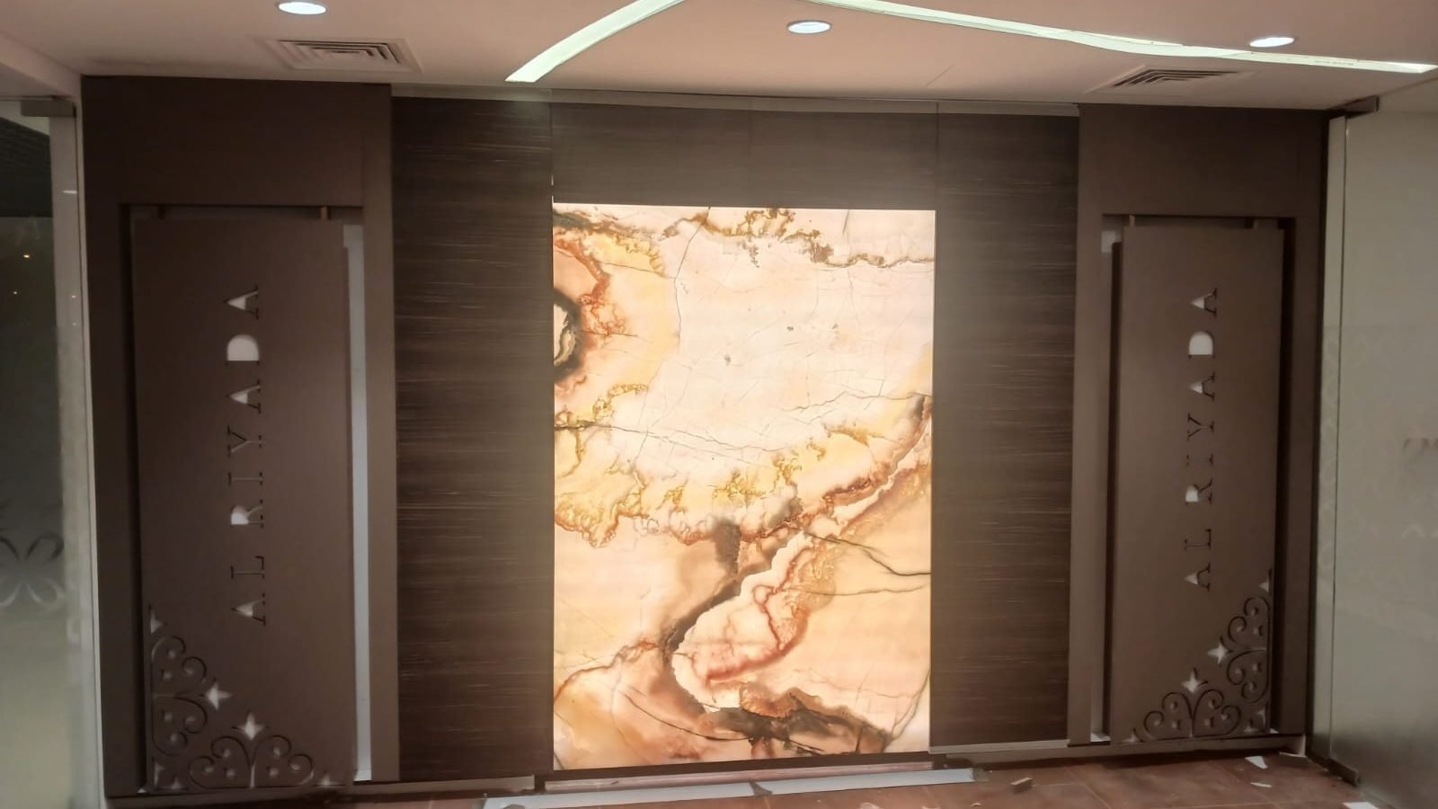 Backlit marble feature wall between timber doors in the Doha Al Khor bank fit-out