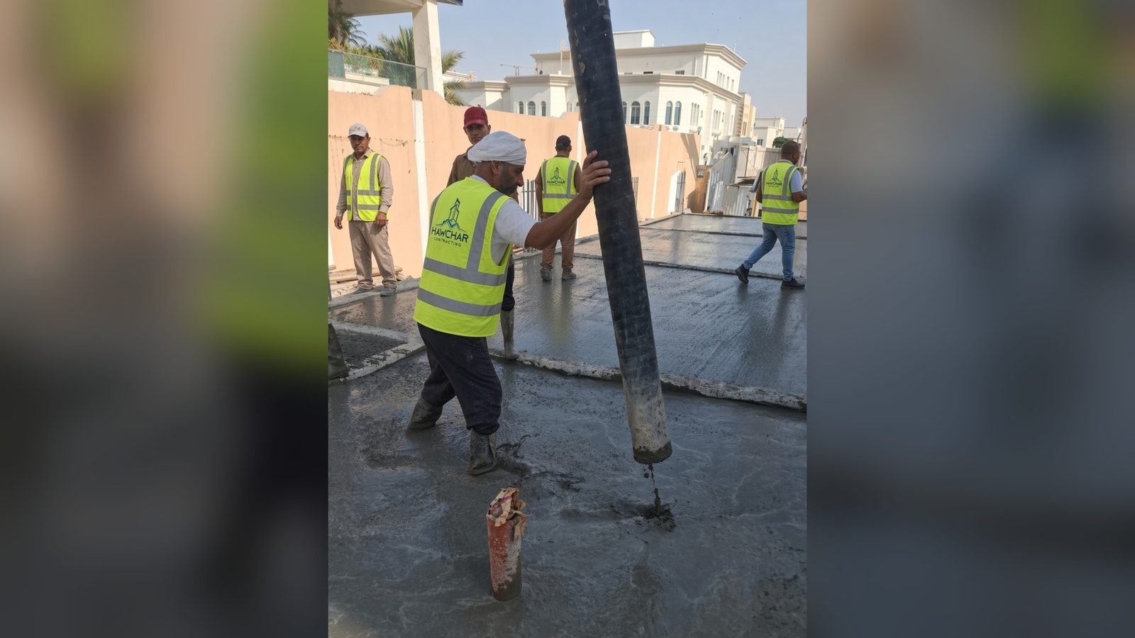 Concrete pump discharging into formwork with the site crew in Qatar