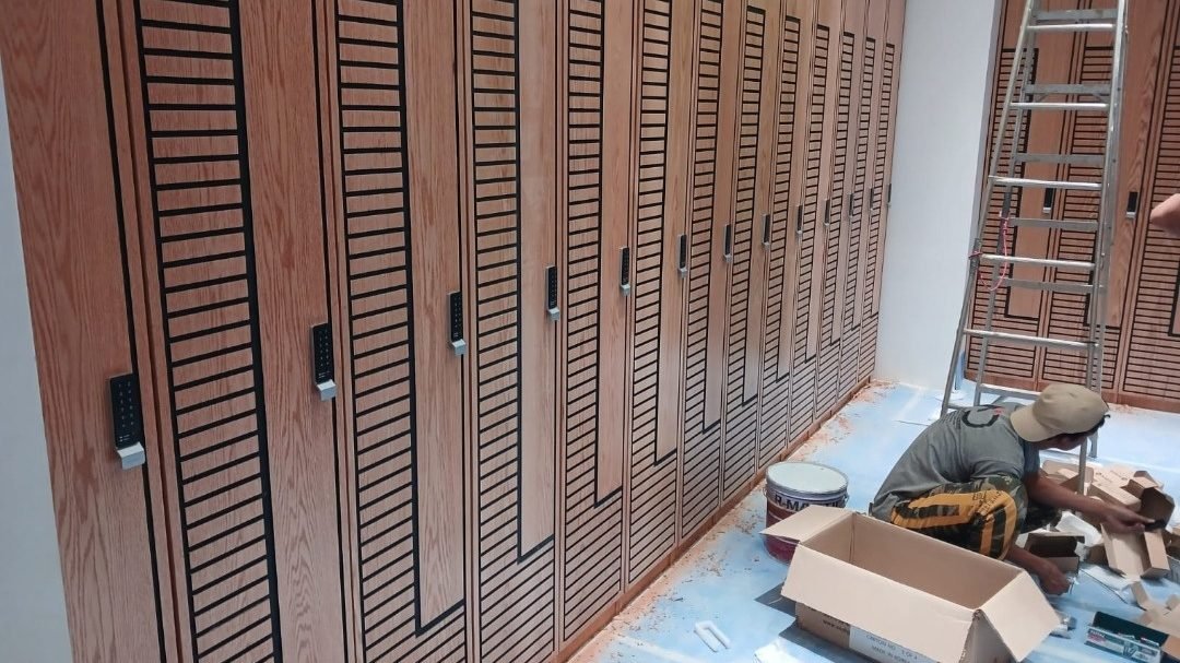 Timber-slatted locker wall installation during the Edge Iconic gym fit-out, Doha