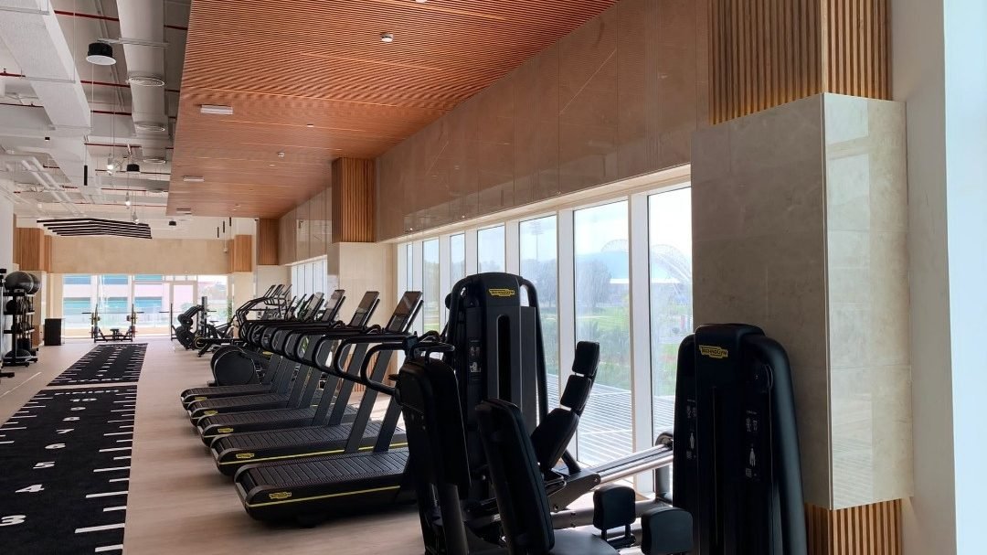 Cardio area with treadmills and timber ceiling in the Edge Iconic gym fit-out, Doha