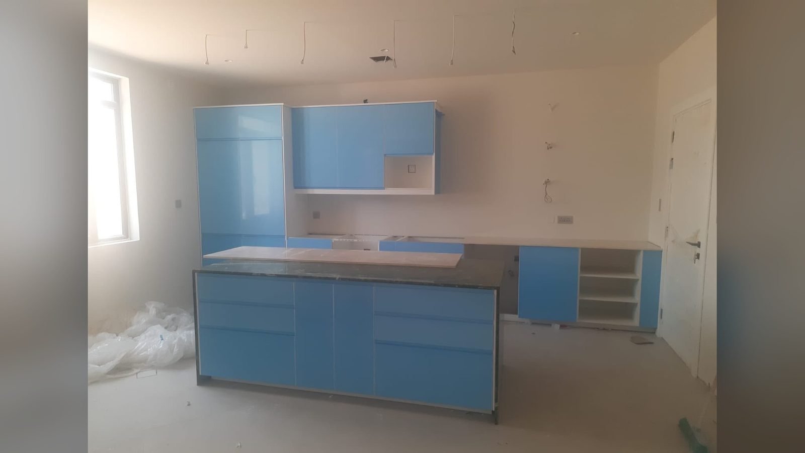 Blue lacquered kitchen with island installed in a villa in Qatar