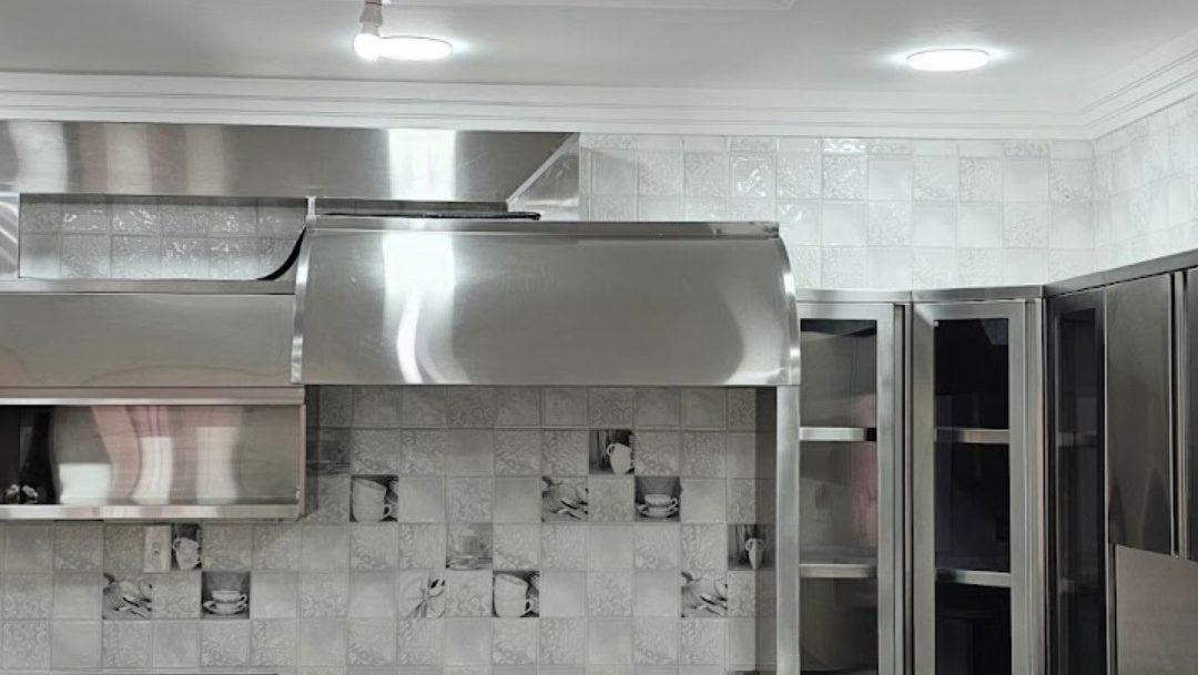 Stainless steel extraction hood and kitchen units in a modern restaurant kitchen, Doha