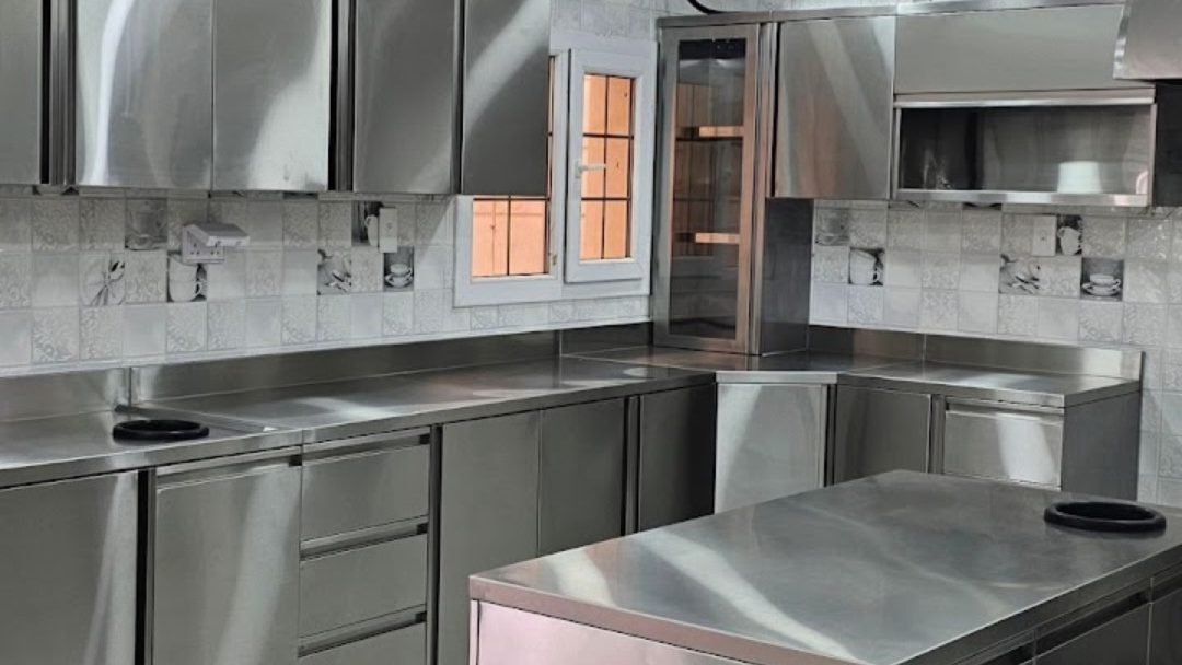 Completed stainless steel restaurant kitchen with marble-look wall tiling in Doha