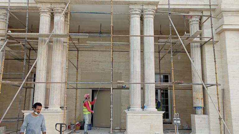 Classical villa elevation under construction with scaffolding and stone columns at Al Anayze, Qatar