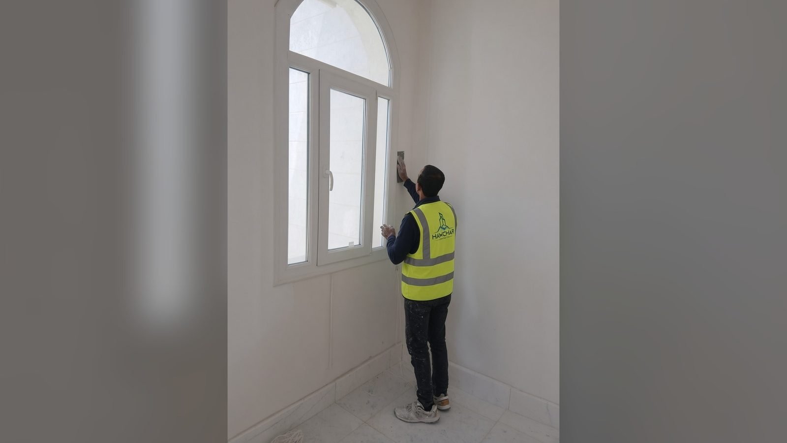 Worker finishing an arched window opening in Doha